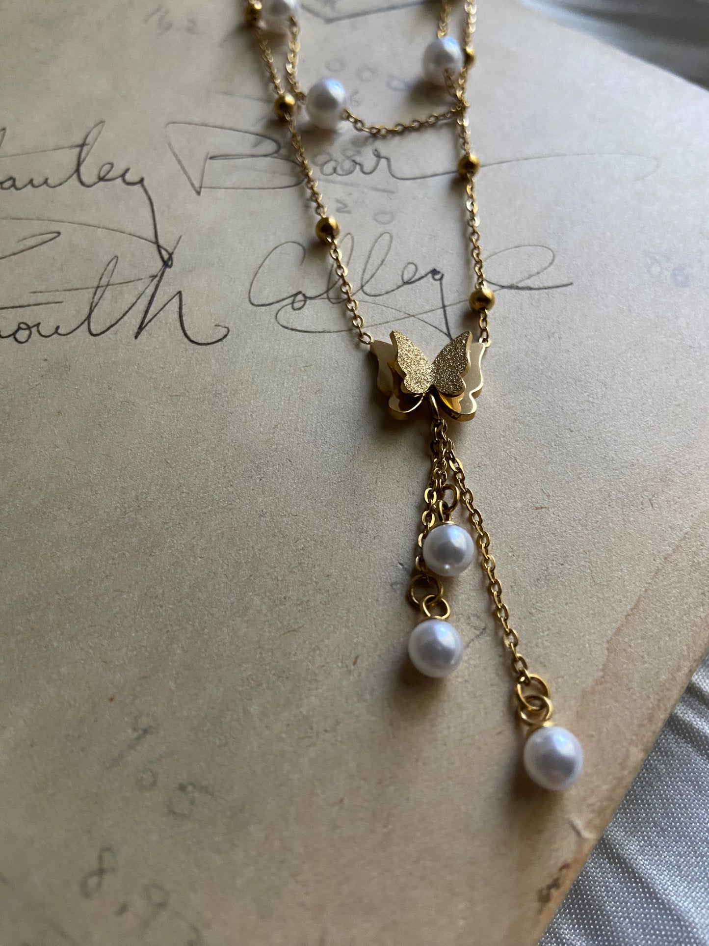 Multilayered gold pearl butterfly necklace